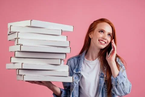 Pretty long ginger red-haired woman holding a lot of boxes with fast food snack Stock Photos