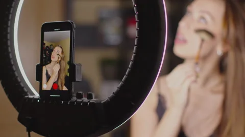 Pretty makeup vlogger creating cosmetic product explainer video using smartphone Video stock 143440793