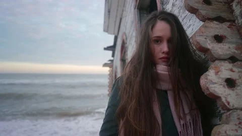 Pretty mixed ethnic woman standing, leaning on old flooded wooden house, chapel Stock Footage 229124935