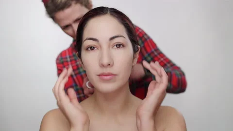 Pretty model blends, smooths makeup with fingertips as hair stylist fixes hair 스톡 동영상 193594260