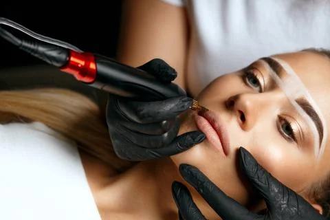 Pretty model having permanent makeup Stock Photos