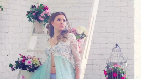 Pretty model in peignoir posing against white wall Video stock 88640141