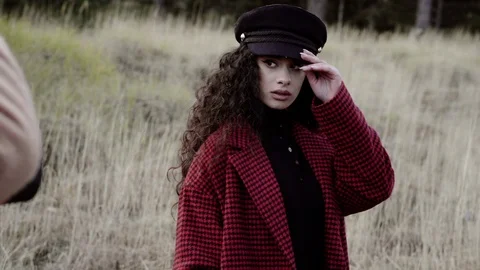 Pretty model with a red coat during a photographic backstage Video stock 125489914