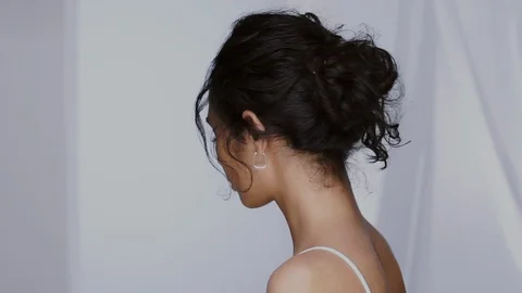 Pretty mulatto model looking from shoulder to camera and smiling with perfect Stock Footage 123729115