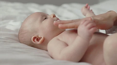 Pretty newborn boy getting stomach massage by mother Stock Footage 188935703