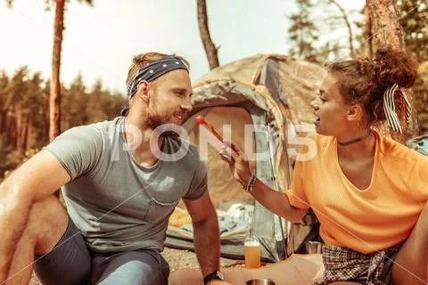 Pretty nice woman giving her boyfriend a tomato to try Stock Photos