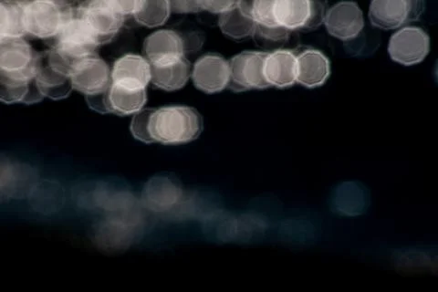 Pretty octagonal bokeh lights calming sun in water reflections graphic resource Stock Photos