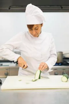 Pretty professional chef cooking in a kitchen. Stock Photos
