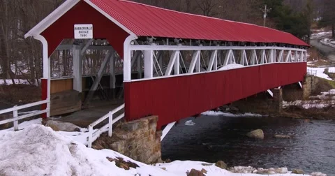 A pretty red covered bridge over a river in winter. Stock-Footage 41622857