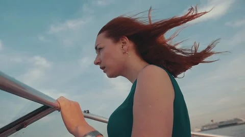 Pretty red hair girl on motor boat. Summer windy evening. Sunset. Blue sky Stock Footage
