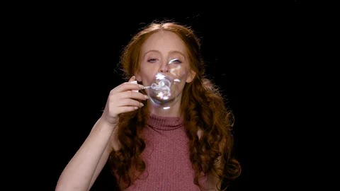 Pretty redhead blowing soap bubbles Stock Footage 100416886
