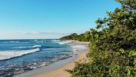 Pretty &amp; relaxing sandy beach with bright blue color and rocks on a sunny day Stock Footage 154615000