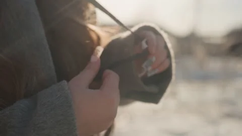 Pretty romantic tying hoodie string, soft golden light on wool coat, gentle Stock Footage 342431291