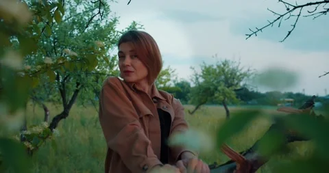 Pretty romantic woman,smiling in the branches of an apple tree Stock Footage 221461819