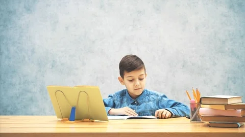 Pretty schoolboy is solving a puzzle, counting, then taking a calculator. Stock Footage 116623943