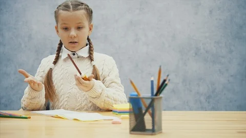 Pretty schoolchild find it difficult to sharpen her brown pencil. Video stock 113070960