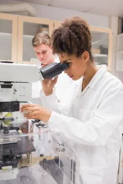 Pretty science student using microscope 写真素材