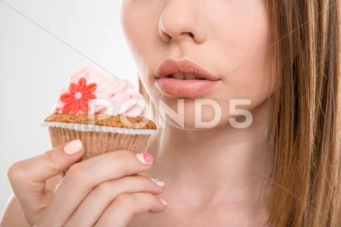 Pretty sensual woman trying to eat a cupcake Stock Photos