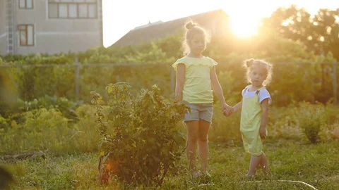 Pretty sisters pose at currant and mother in green garden Stock Footage 113677973