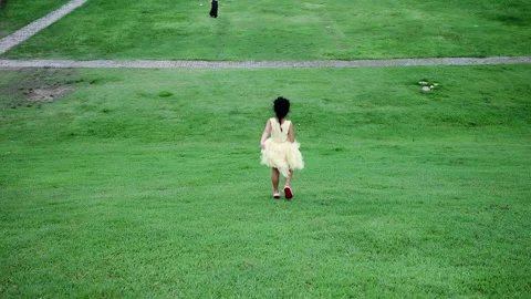 Pretty small girl walking down a hill on grass. Vídeo Stock 247369399