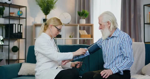 Pretty smiling friendly qualified female doctor measuring old man's pressure Stock Footage 151644639