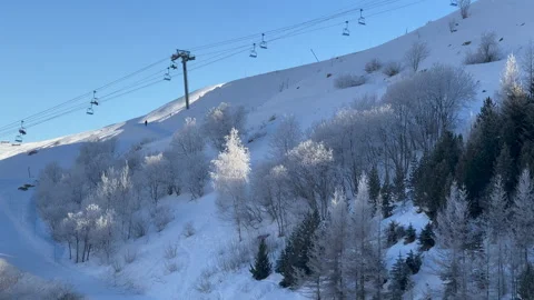 Pretty snow covered trees with ski lift in background in French Alps Video stock 234063639