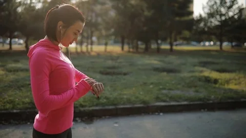 Pretty sportswoman in pink sportswear jogging outdoors, healthy lifestyle Stock Footage