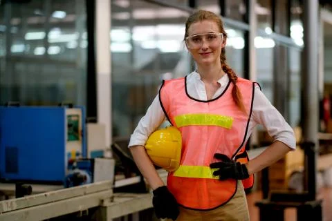 Pretty technician or engineer or worker action of akimbo and hold helmet Stock Photos