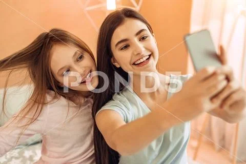 Pretty teenage girls having fun while taking selfies Stock Photos