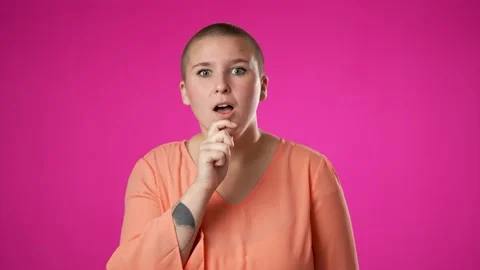 Pretty thinking non binary gender fluid young woman 20s, looks at camera gives Stock Footage 223261101