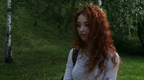 Pretty upset sad red haired girl walking alone. Steadicam. Stock-Footage 52950723
