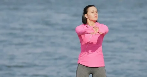 Pretty vigorous sportswoman in pink sportswear warming up before workout Stock Footage