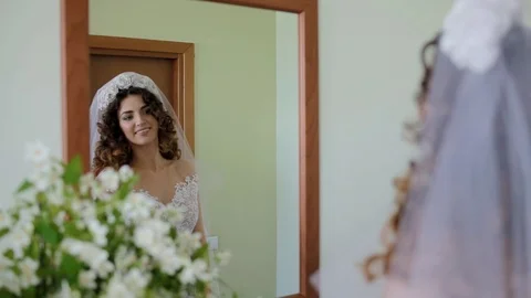 Pretty white bride looking to the mirror Stock Footage 98887086