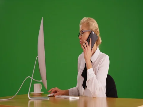 Pretty white woman on the phone at work on green screen Stock Footage