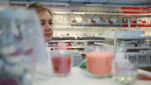 Pretty woman chose candle at shelf Stock Footage 74477853