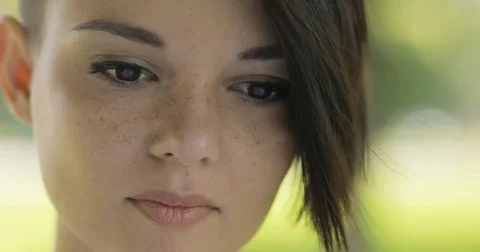 Pretty woman close-up portrait looking to camera at summer day Stock Footage