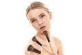 The pretty woman with cosmetic brushes on the white background Photo