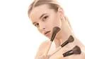 The pretty woman with cosmetic brushes on the white background Photo