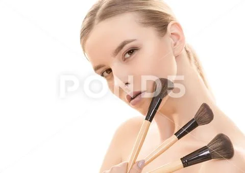 The pretty woman with cosmetic brushes on the white background Stock Photos