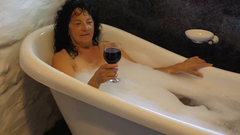 Pretty woman drinking wine while taking the bath 動画素材 116846708