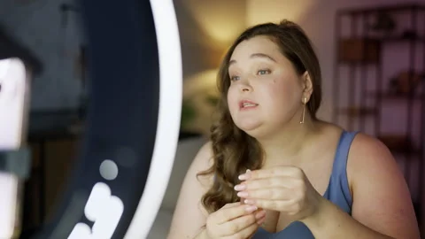 Pretty woman filming makeup tutorial on phone and presenting skincare products Stock Footage 327324171