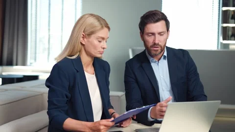 Pretty woman holding documents while director explaining something with laptop Stock Footage 251722347