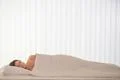 The pretty woman lay in the bed with a white linens Photo