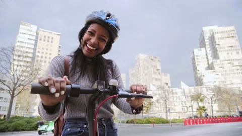 Pretty woman looking camera after ride on electric scooter in the urban city Stock Footage 224111775