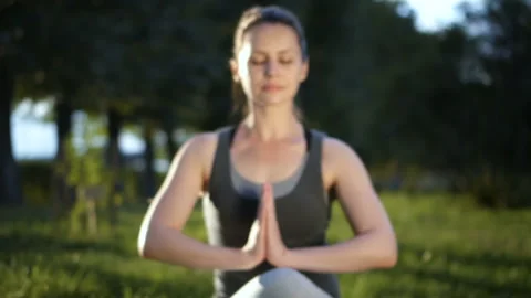 Pretty woman meditating while sitting in lotus pose. Yoga practicing with eyes Stock Footage 122801466