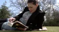 Pretty woman reading a book in the park HD Footage