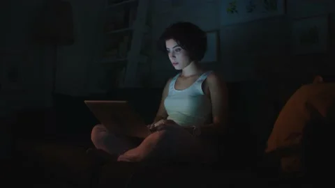 Pretty woman is reading a message on the computer while sitting at her home. Stock Footage 140871549