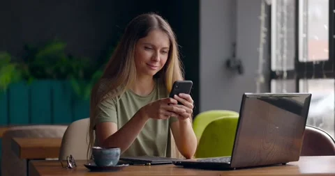 Pretty woman sending message using mobile phone and smiling while working with Video stock 159951935