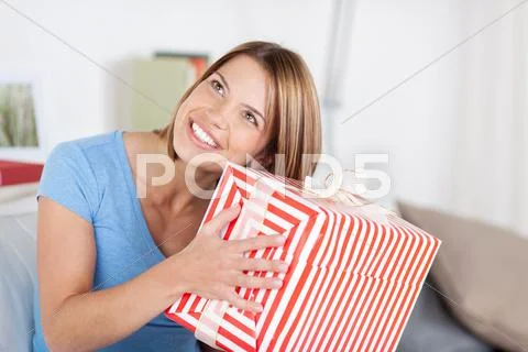 Pretty woman shaking a large present Stock Photos