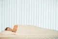 The pretty woman sleeping in the bed with a white linens Photo